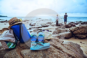 Asian lovers happy on the beach.The sky is bright Travel nature and sitting relax on the rocks at the sea at phuket. in Thailand.