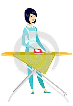 Asian maid ironing clothes on ironing board.