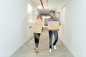 Asian malay couple moving house with box