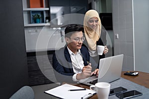 Asian malay couple working together at home