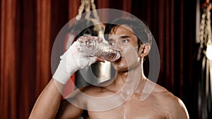 Asian male athlete drinking water. Lift the water from the bottle to drink. After training to develop intense workouts to achieve