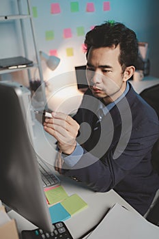 Asian male businessman working in the room. Startup company employees are working in the office at night, overtime, busy work,