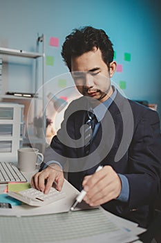 Asian male businessman working in the room. Startup company employees are working in the office at night, overtime, busy work,