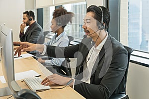 Asian male call center or help desk or telephone support agent working at call center