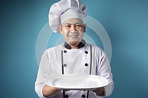 Asian Male Chef Shows Empty White Plate, Presenting Something, Copy Space