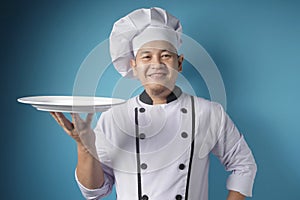 Asian Male Chef Shows Empty White Plate, Presenting Something, Copy Space