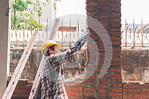 Asian male construction engineer Checking the orderliness of the brick wall work