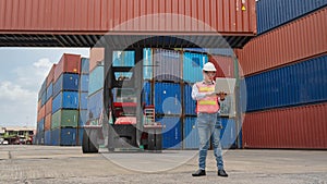 Asian male containers cargo inspector working and containers yard and cargo with background of containers stack and container