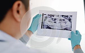 Asian male dentists are analyzing x-ray images of patients at the lab