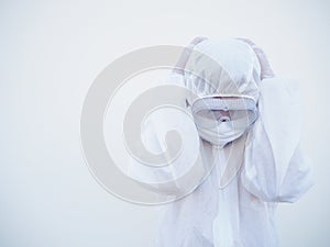 Asian male doctor or scientist in PPE suite uniform showing that feeling strees and headache. coronavirus or COVID-19 concept