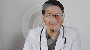 Asian male doctor smiling to camera, giving advice on video call. Online doctor telemedicine telehealth concept