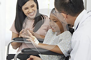Asian male doctor talking to young child