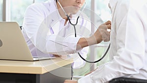 Asian male doctor use stethoscope to examine eldely patient heartbeat