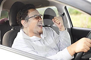 Asian Male Driver Driving His Car and Smiling