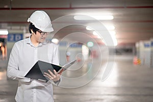 Asian male engineer holding files at construction site