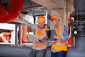 Asian male engineer inspecting pipe fittings and chillers, refrigeration plant refrigeration plant in  factory. men mechanics wear