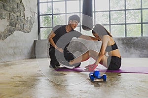 Asian male and female boxing trainers with sandbags in the gym