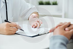 Asian Male and female doctors holding a clipboard.