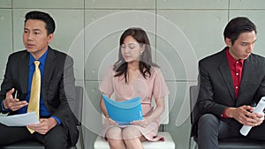 The Asian male and female salespeople are waiting for the interview to be anxious, they look stressed and restless because they ne