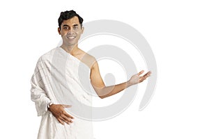 Asian male with ihram presenting copyspace