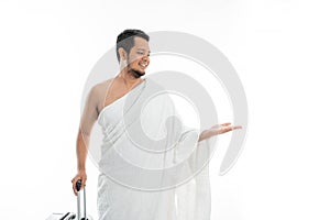 Asian male with ihram presenting copyspace