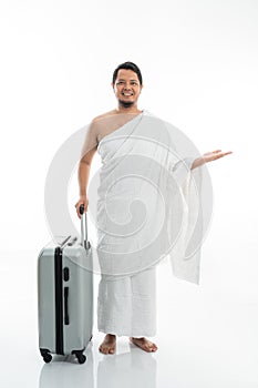 Asian male with ihram presenting copyspace