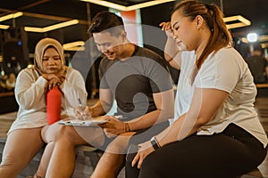 asian male instructor sitting with writing gesture