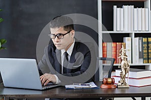 Asian male lawyer working with hammer and scales Goddess of justice, law enforcement officer, judge\'s hammer, as evidence