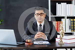 Asian male lawyer working with hammer and scales Goddess of justice, law enforcement officer, judge\'s hammer, as evidence