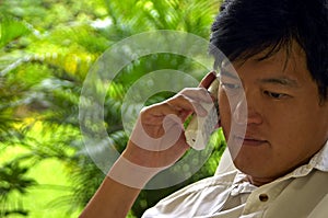 Asian Male Listening Intently On The Phone