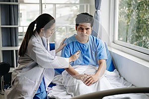 Asian male patient on bed while doctor hands of checking examining his pulse for record the treatment results in hospital