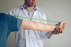 Asian male physical therapist descent working and helping to protect the hands of patients with patient doing stretching exercise