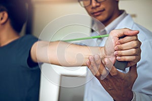 Asian male physical therapist descent working and helping to protect the hands of patients with patient doing stretching exercise