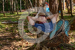 Asian male sleeping in hammock in camping in forest