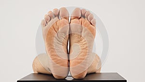 Asian Male soles of feet and barefoot are isolated on chair with white background