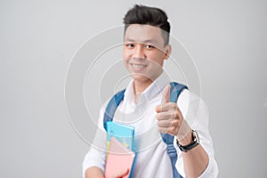 Asian male student making a thumb up sign isolated on white back