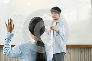 Asian male teacher teaching students at the classroom