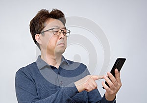 Asian male trying to read something on his mobile phone. poor sight, presbyopia, myopia photo