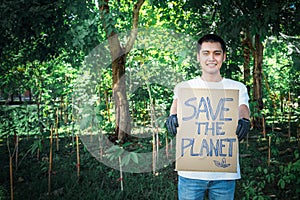 Asian male volunteers standing and holding a save the planet sign