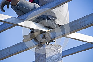 Asian male welder is welding steel beams in process of home renovation. Man worker working for building construction and structure