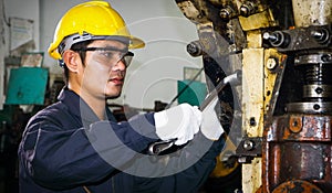 Asian male worker In industries that wear glasses, safety hats and safety uniforms Wrench tool holder stand