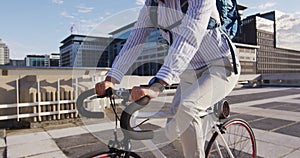 Asian man with backpack riding bicycle on the roof of corporate park