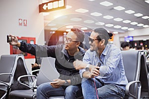 Asian man with backpack  traveler using the smart mobile phone for Video call and taking photo at an airport,Blurry and soft focus