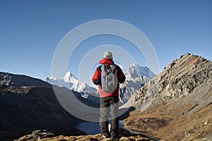 Asian man backpacker male hiker looking at mountains in yading national park, china