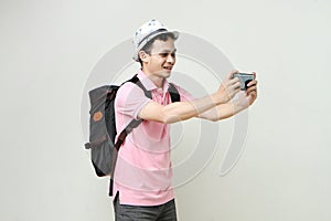 man backpacker take photo with mobile phone. digital nomad and travelling concept. on isolated background