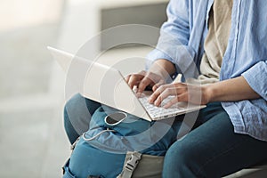 Asian man backpacking using laptop