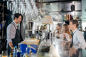 Asian man bartender and his customer talking in roof top bar