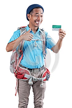 Asian man with a beanie hat and a backpack holding card with a thumb up gesture standing