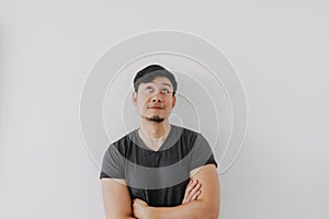 Asian man in black t-shirt crossing his arms isolated on white.