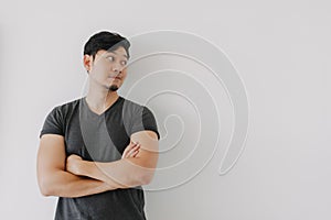 Asian man in black t-shirt crossing his arms isolated on white.